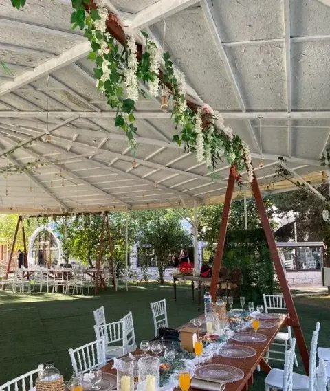 Moonlight Garden Wedding'de yeşil yapraklı süslemeli kapalı alan ve uzun masalar