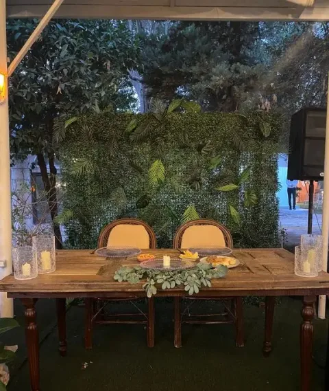 Moonlight Garden Wedding'de yeşil yaprak duvarlı ahşap masa köşesi