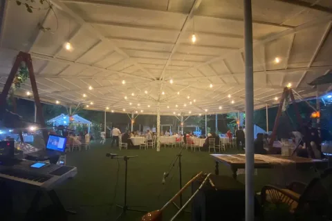 Moonlight Garden Wedding'de ışıklarla aydınlatılmış kapalı davet alanı ve sahne düzeni