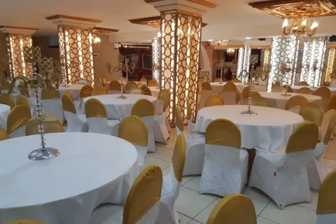 Merve Deluxe salonunda avizeler ve yuvarlak masalar