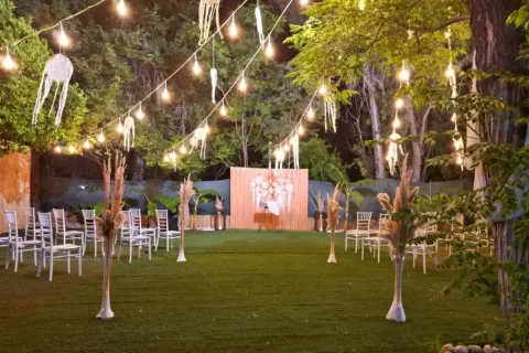 Moonlight Garden Wedding'de ağaçların arasında ışıklandırılmış kır bahçesi ve oturma düzeni